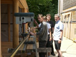 Frank Schmachtenberger, Lehrer der Josef-Greising-Schule Würzburg, mit seinen Schülern an der Bohrmaschine vor der „Waldwerkstatt aktiv“.